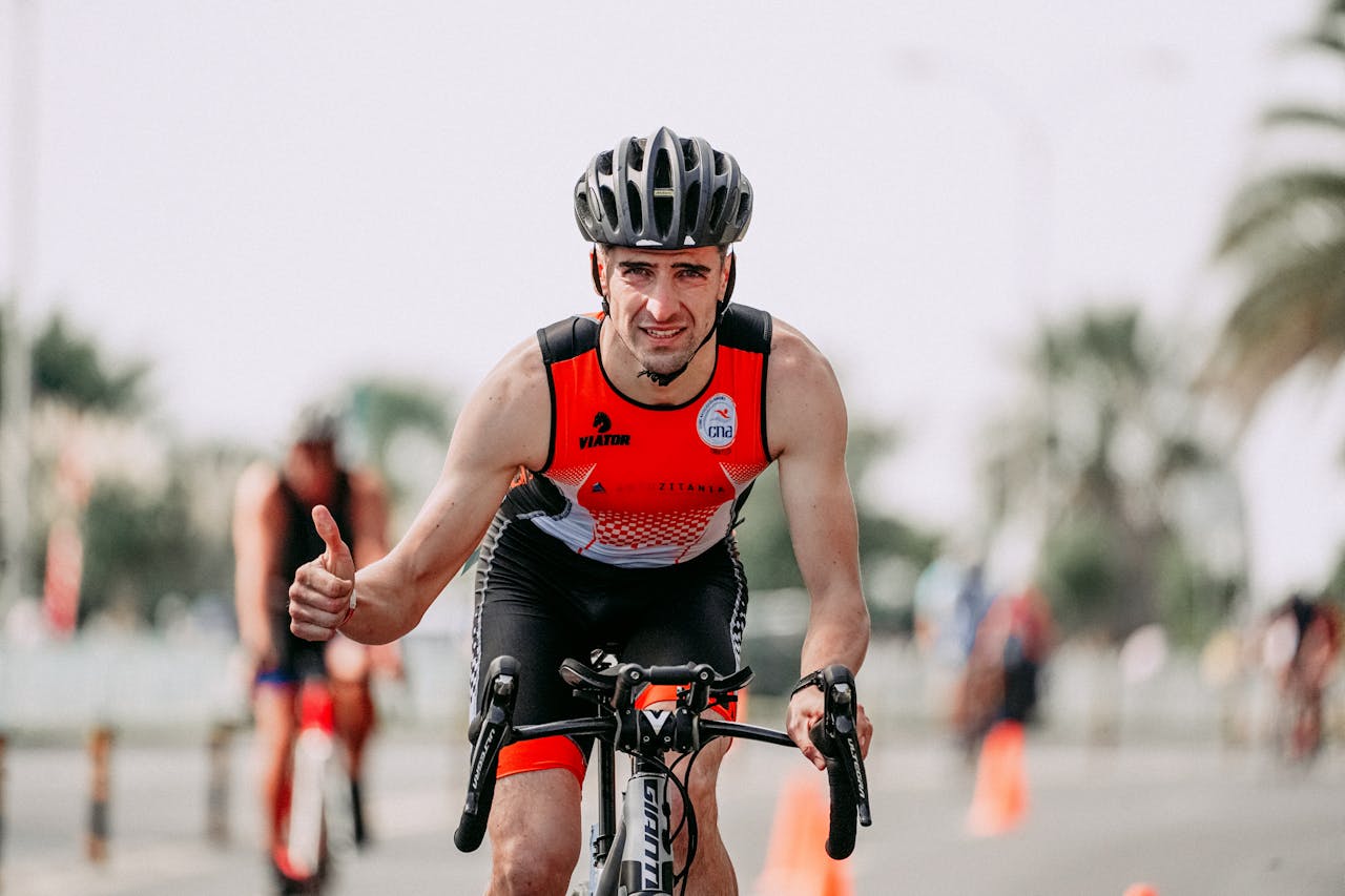 man giving thumbs up while riding road bicycle