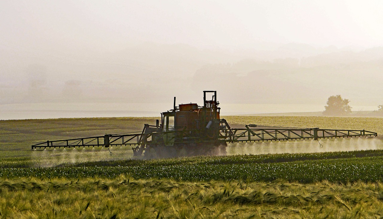 a farmer spraying pesticides on crop